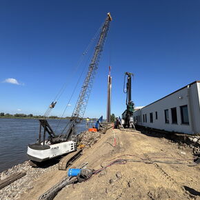 Baustelle der Deicherhöhung in Bremen-Farge mit Seilbagger und Ramme zwischen Weser und Gebäude